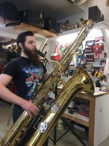 Marcel with a contrabass saxophone that is taller than he is